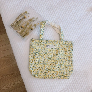 Close-up of small floral canvas tote bag with yellow blossoms and animal pattern label