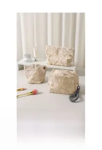 Detailed set of beige linen makeup bags with fringe edges and flower zipper pulls