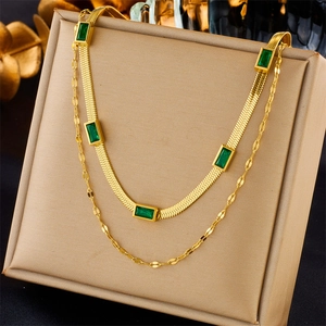 Double-layered gold necklace with flat snake chain and emerald green rectangle gemstones
