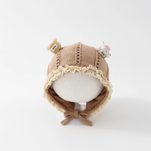 Detail of khaki baby knit hat with lace trim, Smile patch and cute earflap ties