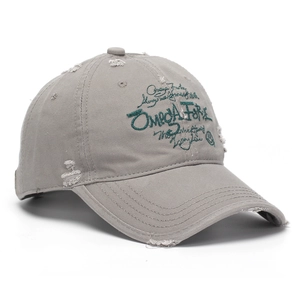 Détail d'une casquette grise vieillie avec broderie Omega Force verte et effet usé chic