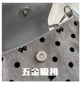 Gros plan sur le fermoir magnétique et le tissu à pois d'un sac à bandoulière chic
