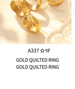 Nahaufnahme von goldenen Ringen mit klassischer Steppmuster-Gravur auf Stoffhintergrund