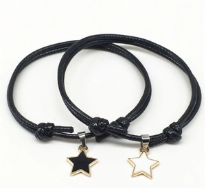 Close-up of adjustable black wax cord bracelets with black and white star charms