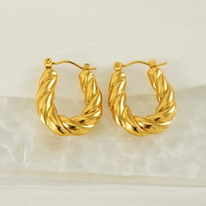 Détail macro de boucles d'oreilles torsadées en U plaquées or 18 carats sur verre
