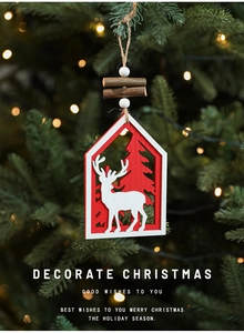 Detail of wooden Christmas house pendant with reindeer and tree on glowing festive branches