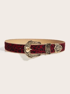 Detail of red leopard print belt with ornate golden floral embossed buckle and tip