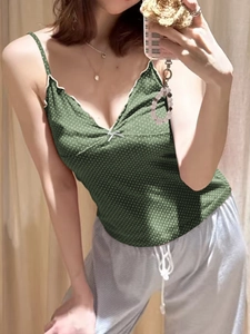 Detail of green polka dot camisole with white lace trim and small bow on the front