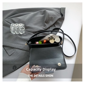 Detail view of the spacious interior of this black crossbody bag showing daily essentials