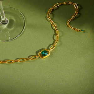 Detail of square green gemstone pendant on gold-plated stainless steel chain necklace