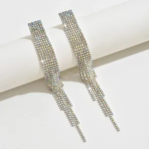 Macro shot of silver cascading tassel earrings with sparkling white rhinestones on stand