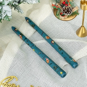 Détail de bougies effilées bleu canard avec pain d'épice et motifs festifs
