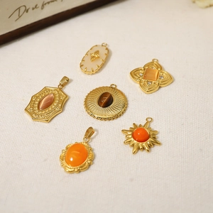 Detailed view of six vintage gold stainless steel pendants with various natural stones