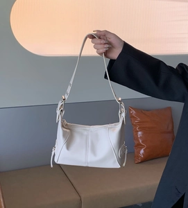 White PU leather shoulder bag featuring silver zippers and adjustable straps in soft light