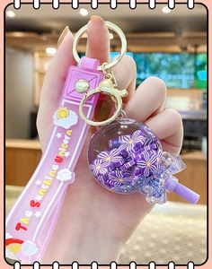 Detailed close-up of a purple unicorn drifting bottle keychain with floral glitter sequins