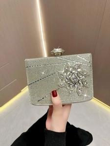 Close-up of silver evening clutch with rhinestones, crystal flowers and gemstone clasp