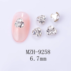 Gros plan détaillé des breloques à ongles fleurs à trois pétales de 6,7 mm avec strass