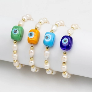 Detail of four freshwater pearl bracelets with colorful evil eye glass beads on display