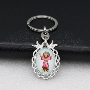 Detail of silver religious keychain featuring Infant Jesus and openwork texture
