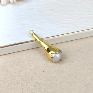 Detail view of a natural baroque freshwater pearl with a gold-plated bezel edge