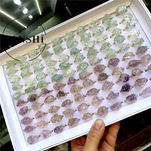 Detailed collection of handmade wire-wrapped natural crystal rings in a display box