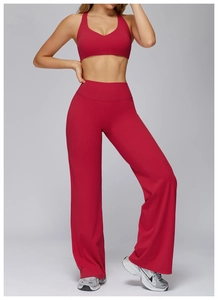 Detail of high-waisted flared yoga pants and v-neck sports bra in deep burgundy fabric