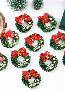 Mini Christmas wreaths with red bows, gold bells and Merry Christmas lettering on white
