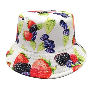 Close-up of strawberry and blueberry print patterns on white summer cotton sun hat