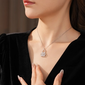 Dettaglio della collana d'argento con ciondolo a borsa in cristallo sul collo della modella