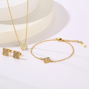Macro detail of gold-plated jewelry set with sparkling cubic zirconia clover patterns