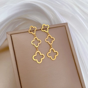 Golden titanium steel triple layered clover earrings with matte texture on jewelry box