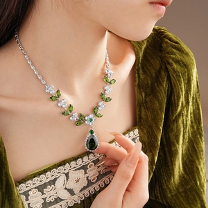 Close-up of leaf necklace with green teardrop zircon and white floral stones