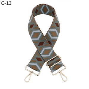Close-up of geometric diamond pattern shoulder strap with gold metal lobster swivel hooks