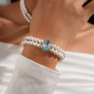 Close-up of double-layer pearl bracelet with light blue oval gemstone in retro style
