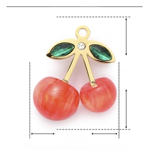 Macro detail of a 25mm pink cherry pendant with gold leaves and rhinestone accents