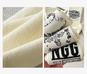 Detailed texture of cream cotton socks featuring embroidered New York and Dream Up patterns