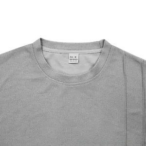 Detail of grey sports t-shirt neckline showing 100% polyester fabric and M size label