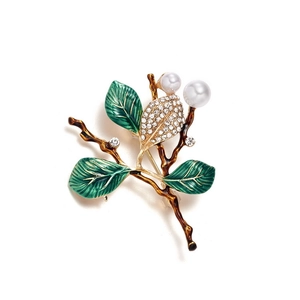Detail of leaf brooch with green enamel leaves, creamy pearls, and sparkling crystals