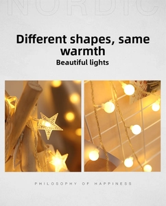Close-up of star and ball shaped solar LED string lights emitting warm yellow light