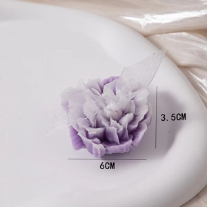 Detail of purple carnation scented candle with 6cm diameter size labels on a white tray