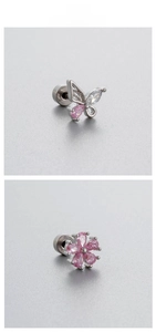 Détail macro de piercings cartilage en acier titane avec papillon et fleurs en zircon rose