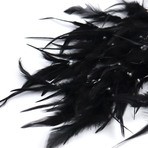 Close-up of black feathers with white faux pearls on a Tree of Life dream catcher