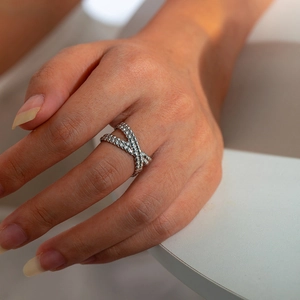 Close-up of silver textured criss-cross ring showing retro geometric leaf design details