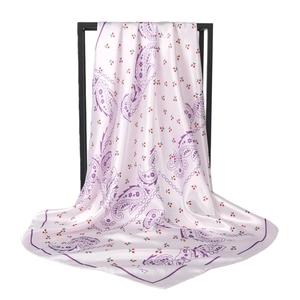 Pink satin square scarf with purple paisley and cherry print displayed on a minimal stand