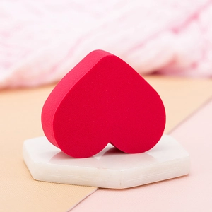 Macro detail of a soft heart-shaped red makeup sponge for wet and dry cosmetic application