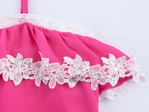 Dettaglio dell'abito in chiffon rosa con pizzo bianco e paillettes argentate lucide