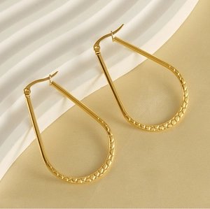 Macro detail of French vintage gold oval earrings with unique textured finish and clasp