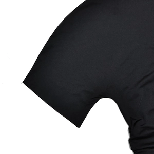 Vue détaillée du tissu noir élastique montrant la texture et la couture de la manche