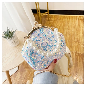 Close-up of a mini sequin shell bag featuring pearl handle and gold chain strap