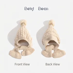 Winter knit baby hooded scarf with pompom and cable pattern in cream white